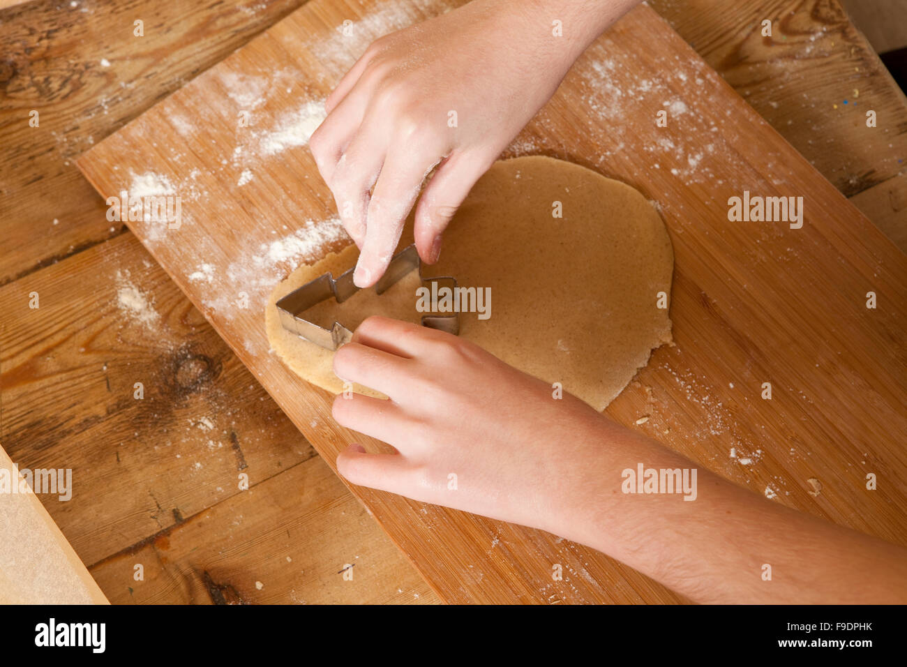 Preparazioni di natale. La realizzazione di pan di zenzero è un tempo onorata tradizione. Una giovane ragazza è accuratamente il taglio di un albero. Foto Stock