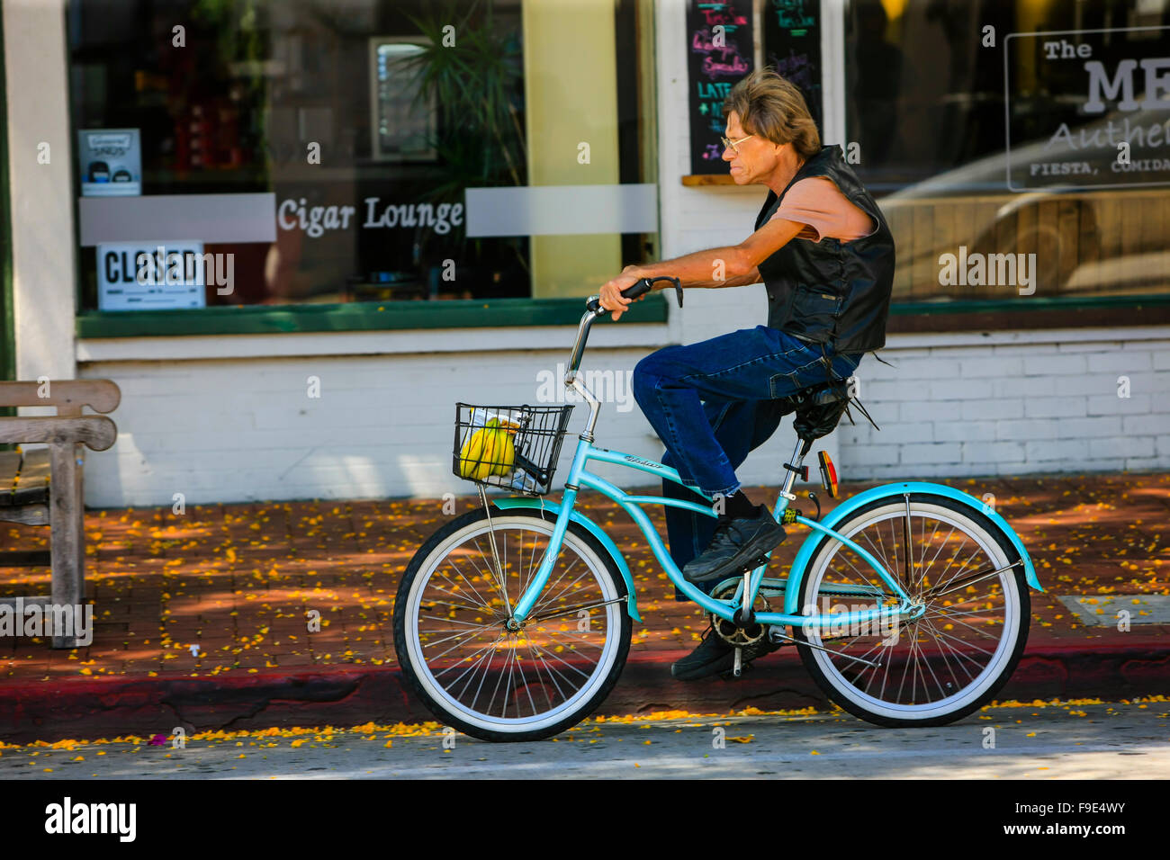 Uomo a cavallo di un blue beach cruiser bicicletta nel centro cittadino di Santa Barbara in California Foto Stock