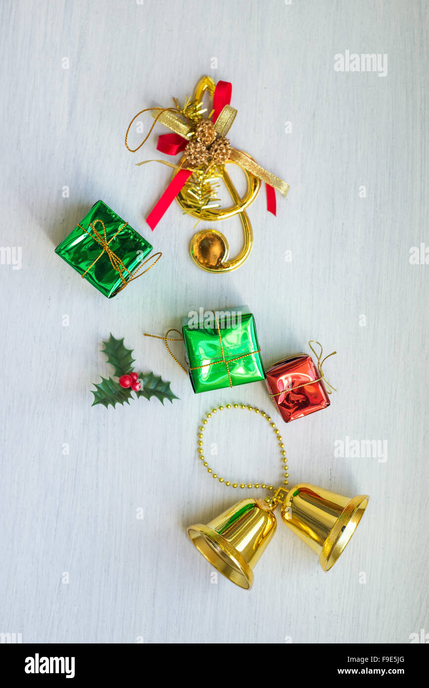 Natale coriandoli - Bell, dono, candy stick collocati su uno sfondo bianco. Angolo di cui sopra. Foto Stock
