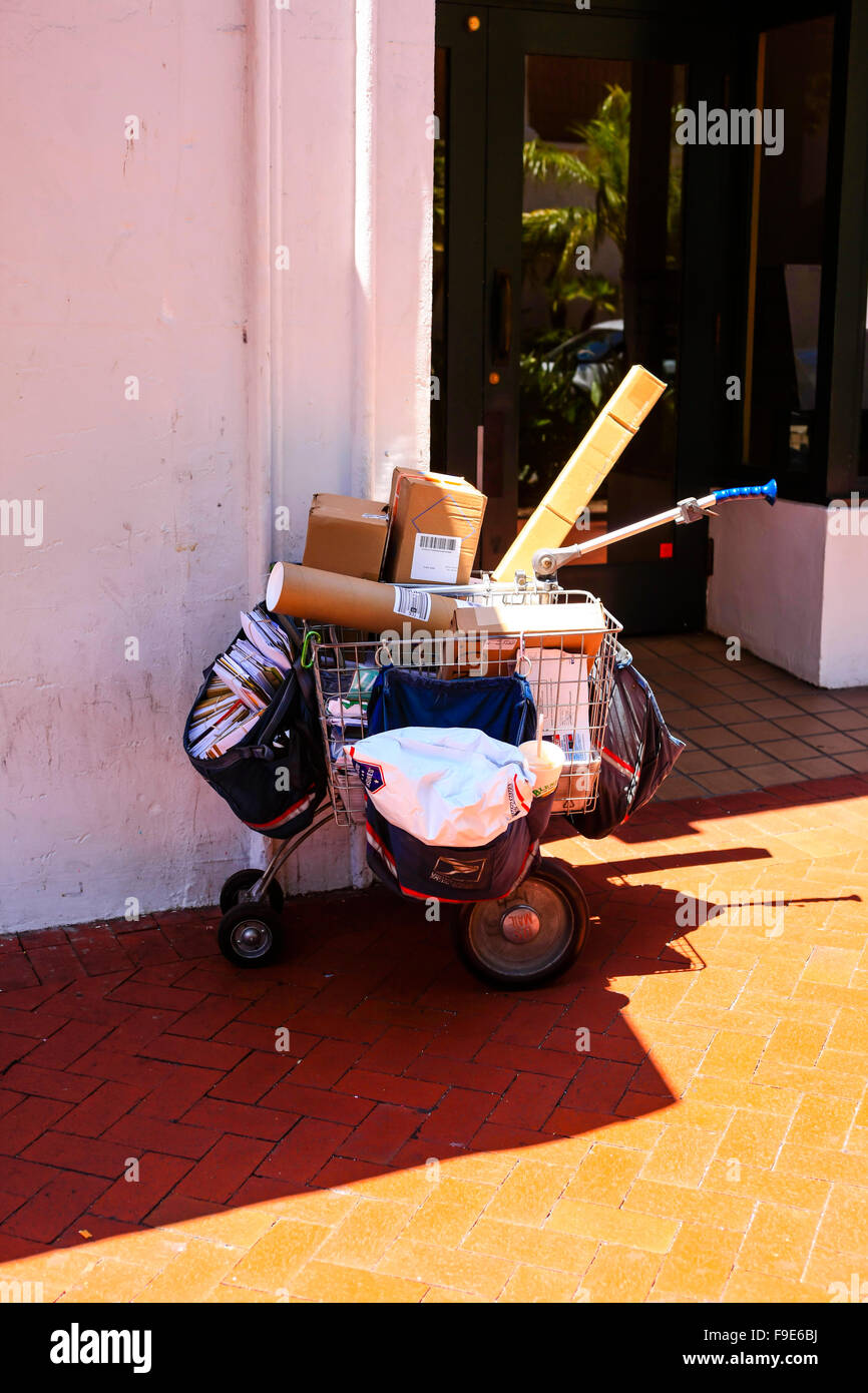 Pacchi e lettere appartenenti ai fornitori del servizio universale al di fuori di un negozio nel centro cittadino di Santa Barbara CA Foto Stock