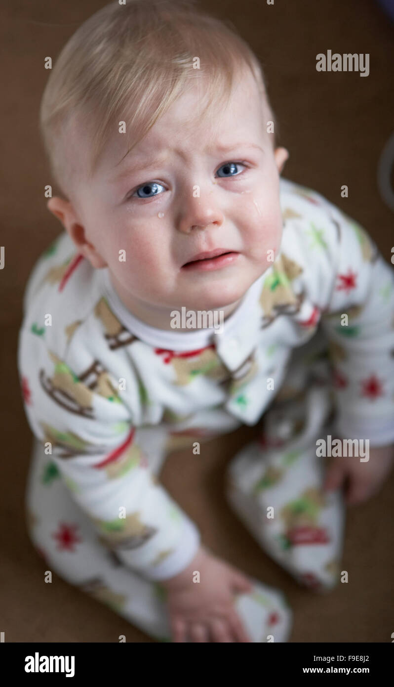 Blonde bionda pelose triste pianto del bambino con le lacrime nei suoi occhi blu Foto Stock