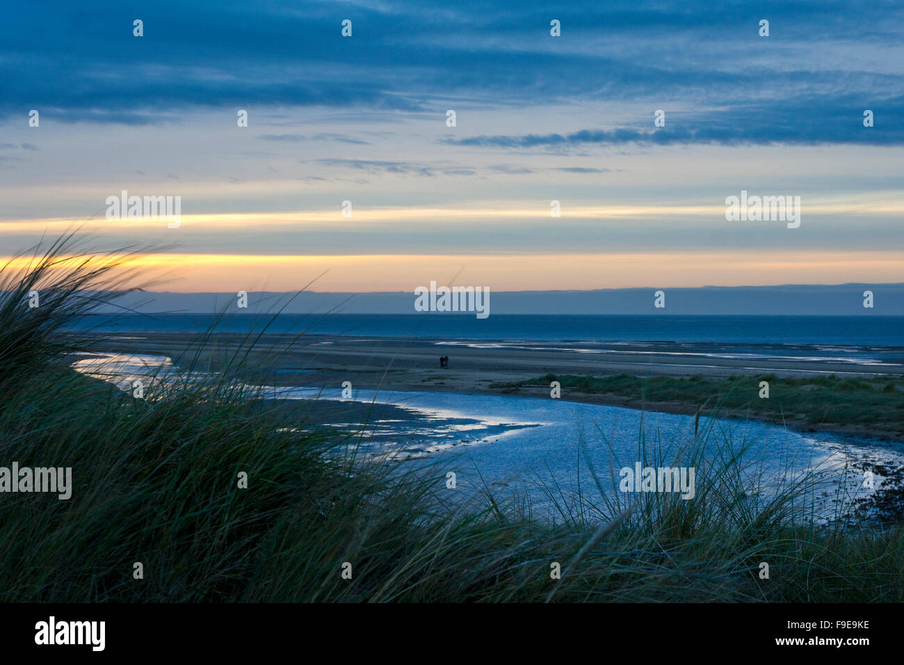 Coppia distanti a piedi sulla spiaggia e le dune a Holme-next-il-mare, Norfolk, Inghilterra Foto Stock