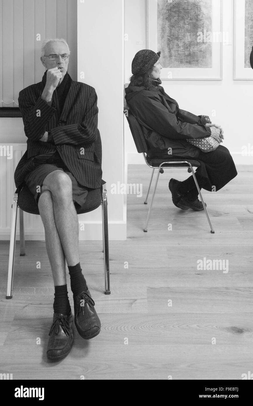 Due caratteri prendendo il tempo a una fiera, ma ignorando ogni altra, Black & White, lungo le gambe, indossare pantaloncini corti, maschio e femmina Foto Stock