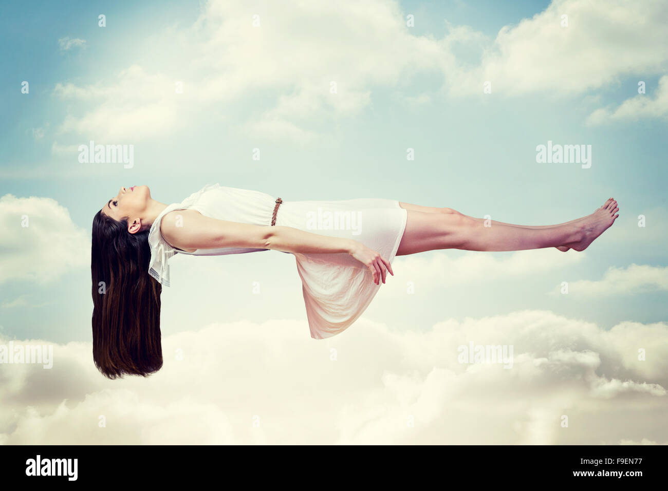 Immagine composita della ragazza in abito bianco galleggianti in aria Foto Stock