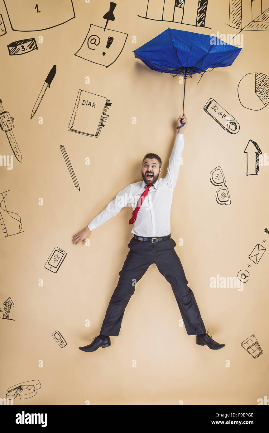 Bello manager con ombrello cadere verso il basso. Studio shot su sfondo beige. Foto Stock