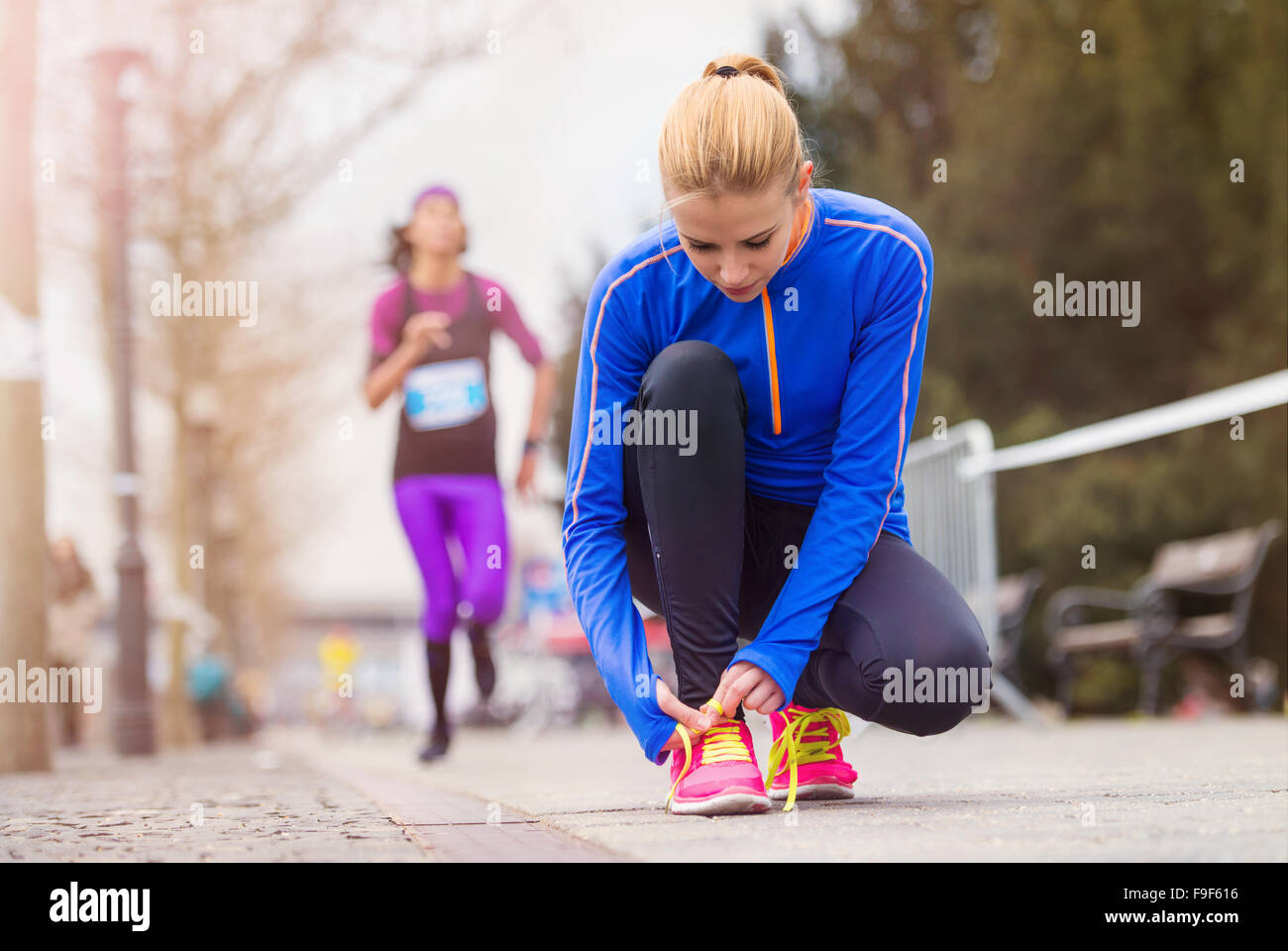 Giovani runner nella città di gara lacci delle scarpe di legatura Foto Stock