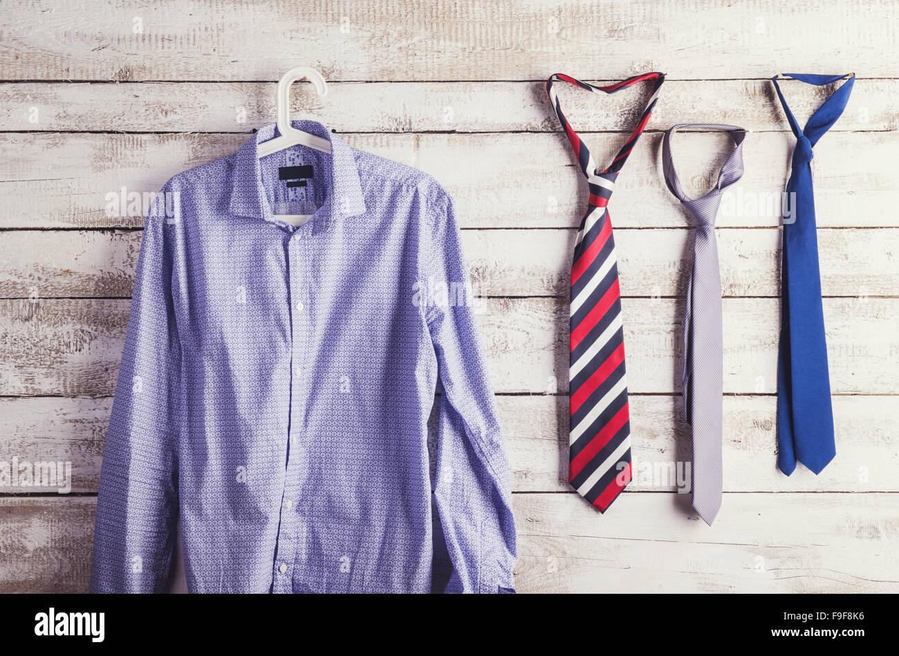 Padri giorno composizione della camicia e tre tiranti appendere alla parete di legno dello sfondo. Foto Stock