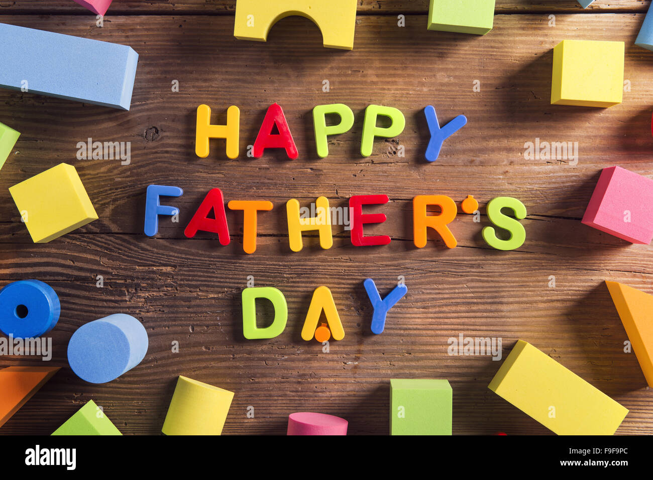 I padri felice giorno segno e giocattoli colorati di cui su sfondo di legno. Foto Stock
