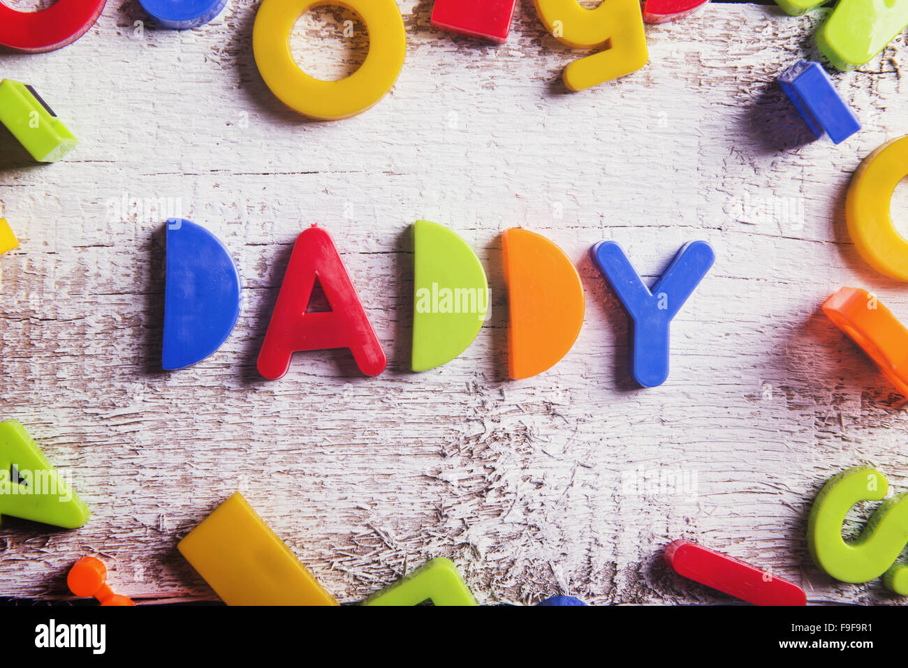 Il Daddy segno e giocattoli colorati di cui su sfondo di legno. Foto Stock