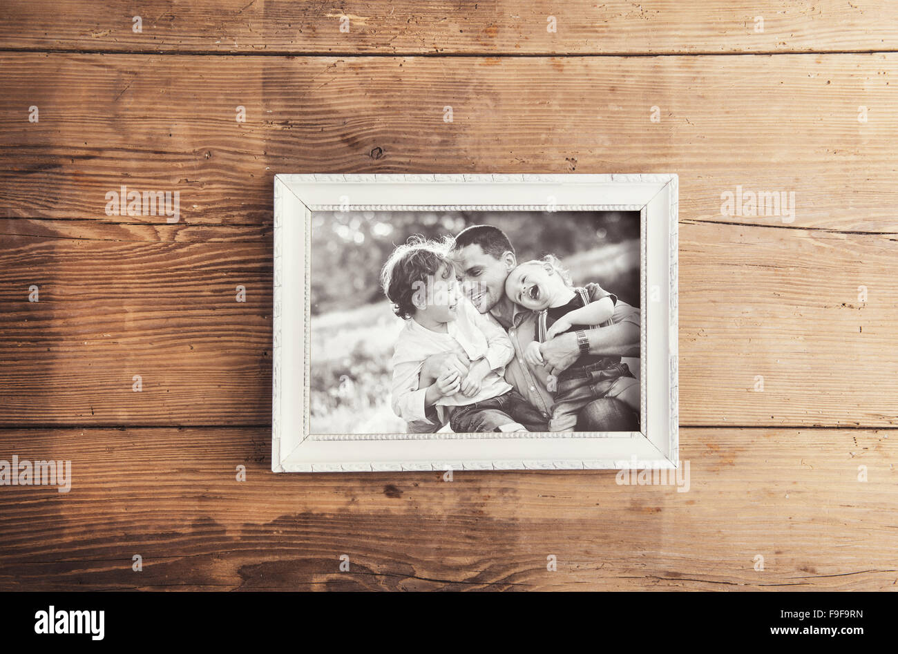 Picture Frame con foto di famiglia prevista su un sfondo di legno. Foto Stock