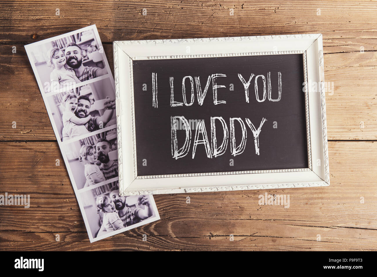 Cornice per foto con I love you daddy segno e le foto istantanee su sfondo di legno. Foto Stock
