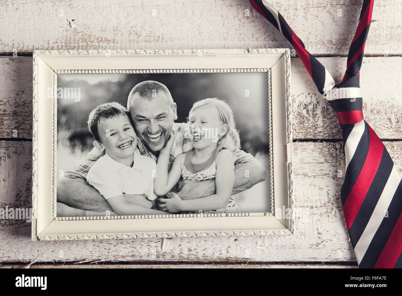 Picture Frame con foto di famiglia e fascetta colorata prevista su sfondo di legno. Foto Stock