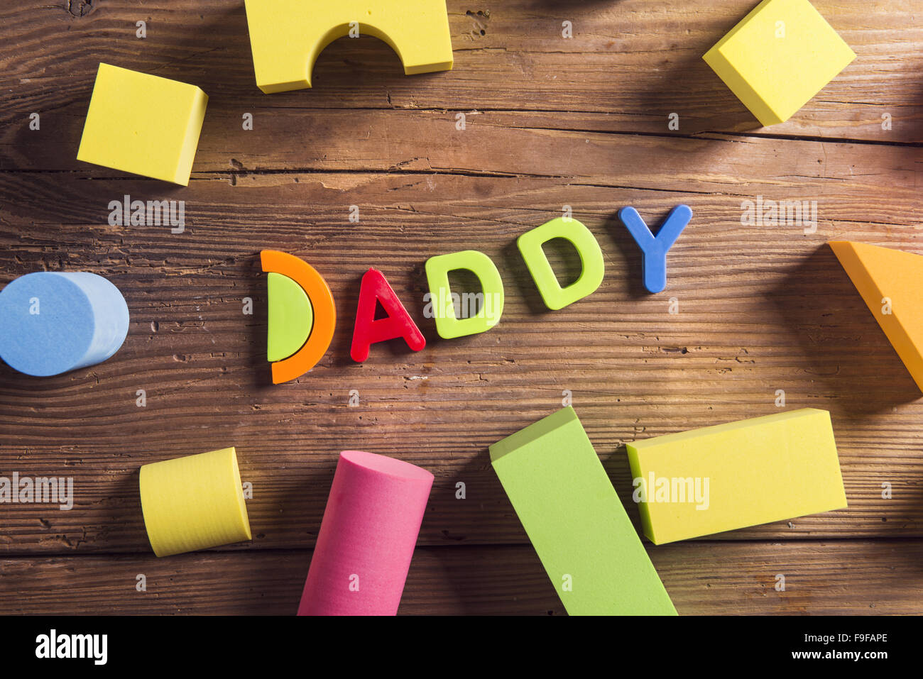Il Daddy segno e giocattoli colorati di cui su sfondo di legno. Foto Stock