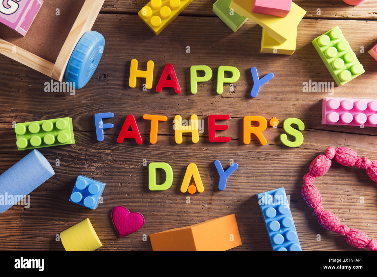 I padri felice giorno segno e giocattoli colorati di cui su sfondo di legno. Foto Stock
