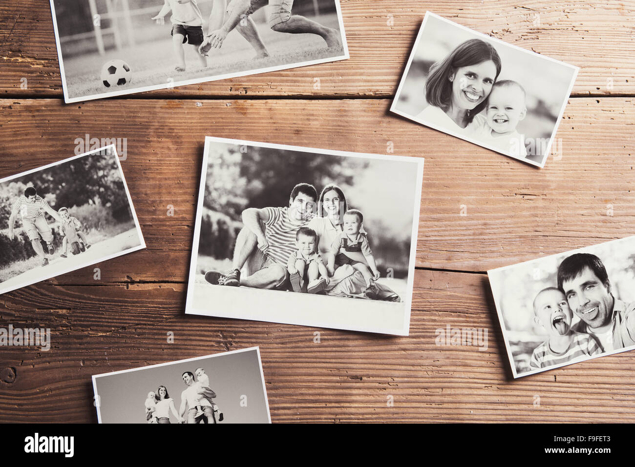 In bianco e nero alle foto di famiglia prevista su un tavolo. Studio shot su sfondo di legno. Foto Stock