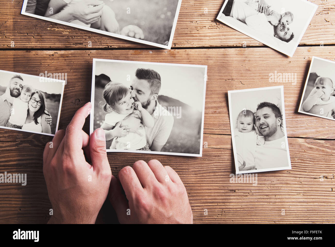 In bianco e nero alle foto di famiglia prevista su un tavolo. Studio shot su sfondo di legno. Foto Stock