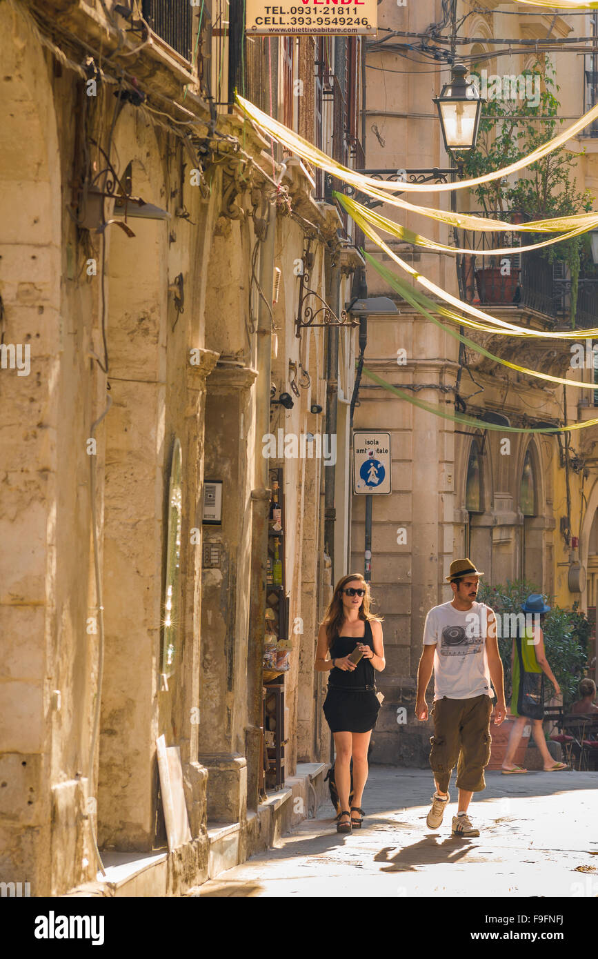Coppia millenaria, vista di una giovane coppia che cammina attraverso il centro storico di Ortigia, Siracusa (Siracusa) Sicilia, Foto Stock