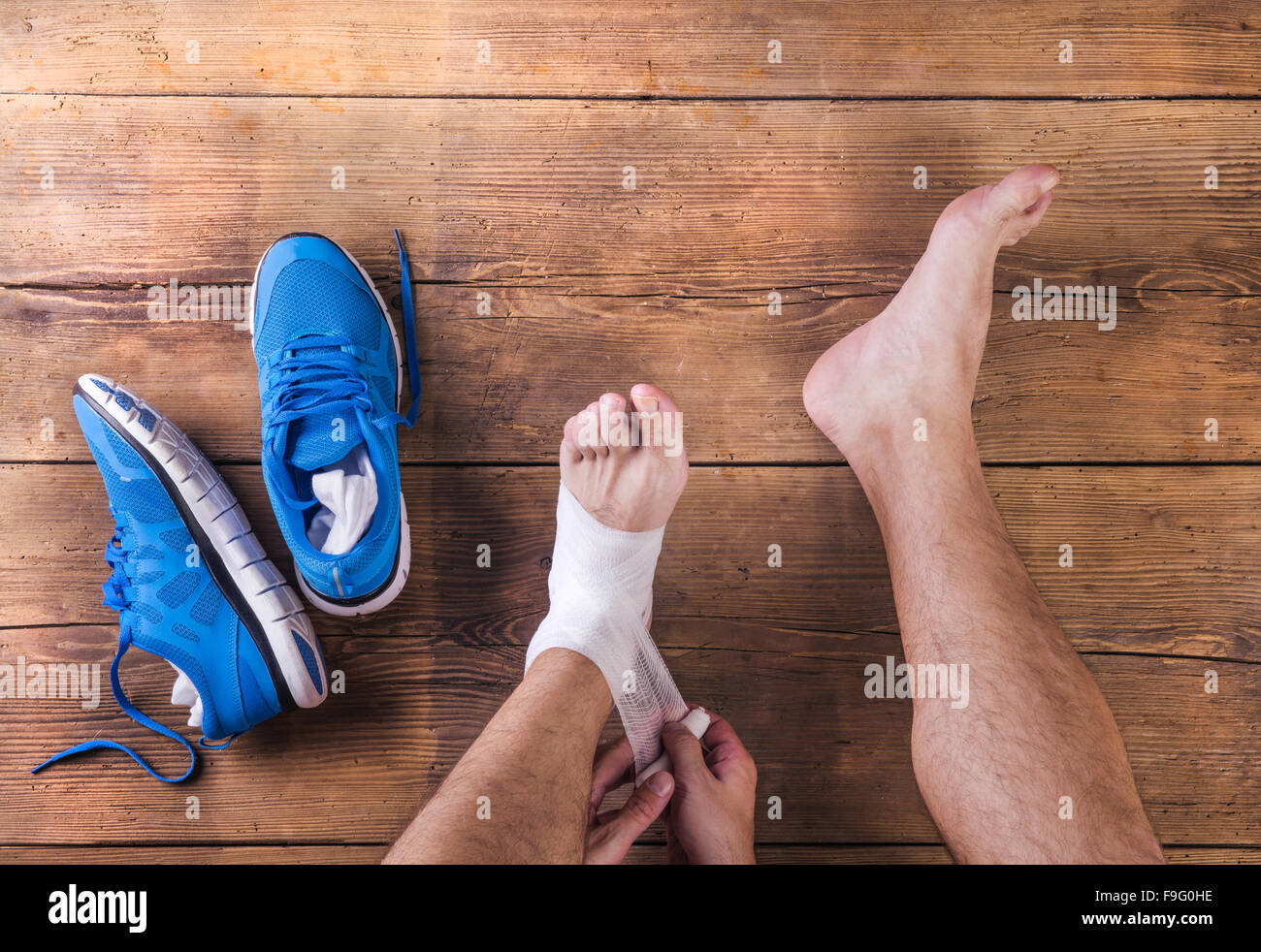 Irriconoscibile feriti runner seduto su un pavimento di legno sfondo Foto Stock