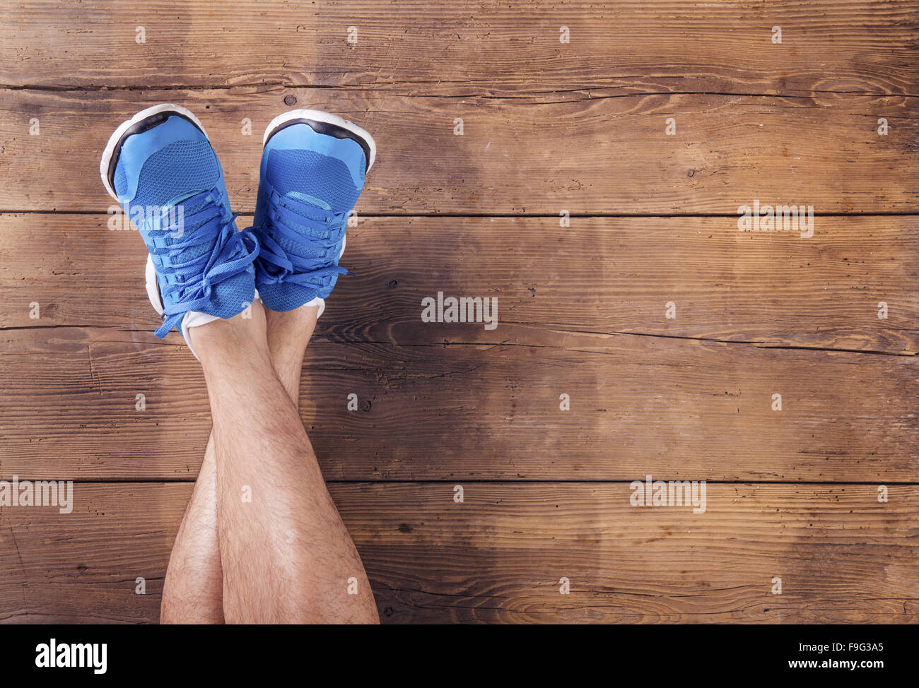 Le gambe di un runner su un pavimento di legno sfondo Foto Stock