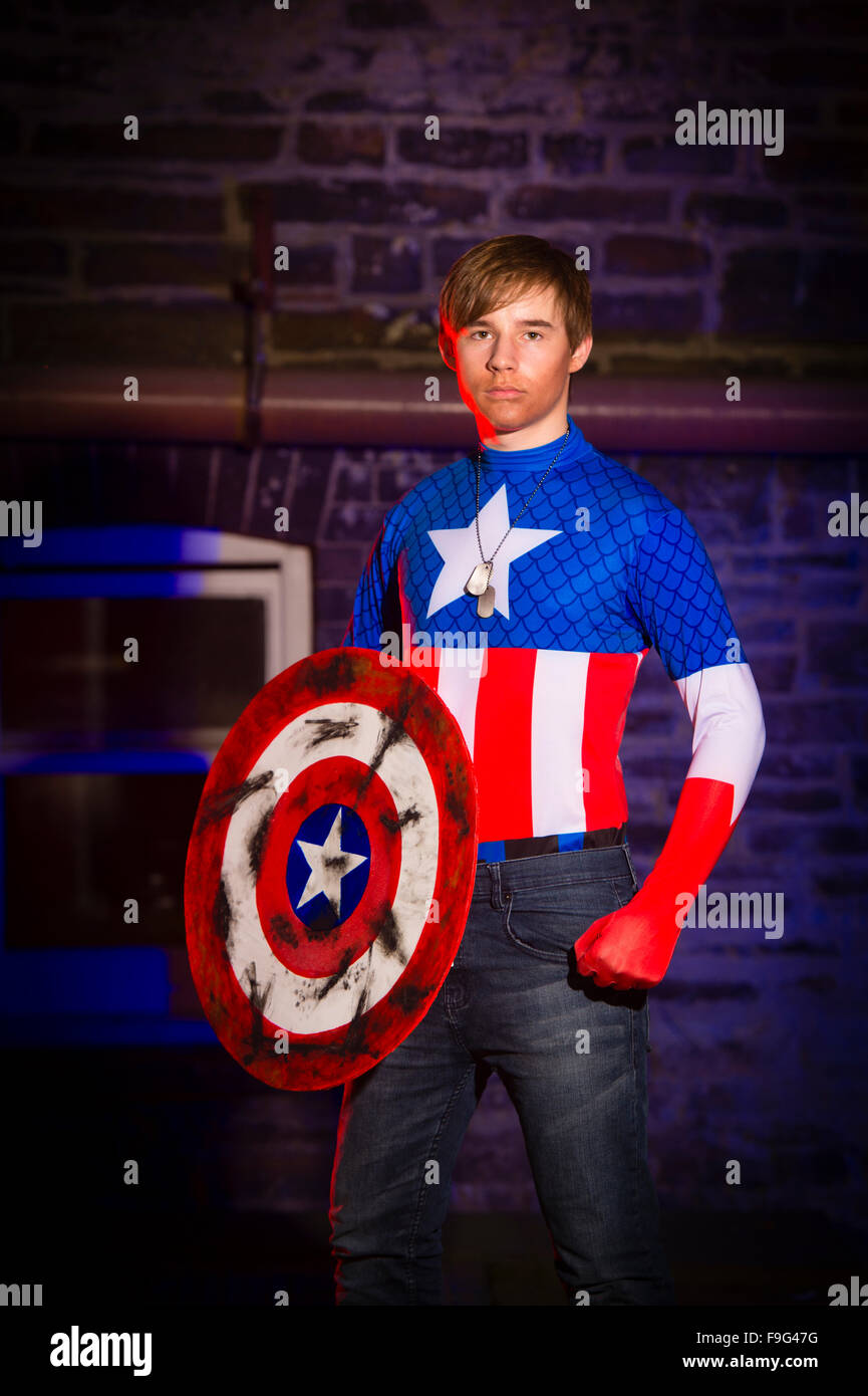 Un uomo maschio ragazzo studente universitario vestito in costume costume come supereroe Capitano America Foto Stock