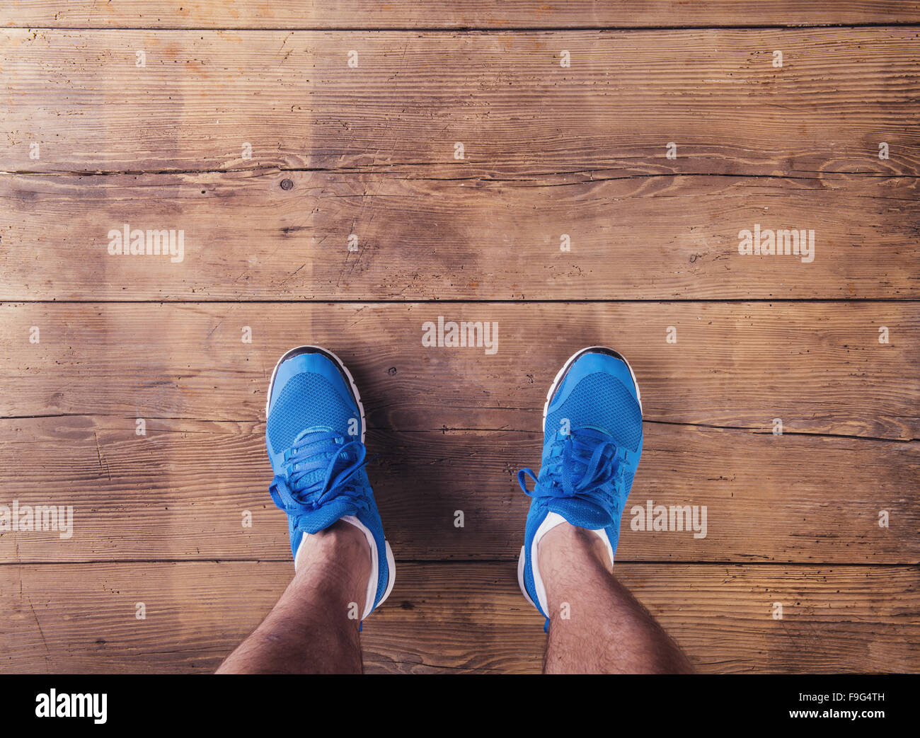 Le gambe di un runner su un pavimento di legno sfondo Foto Stock