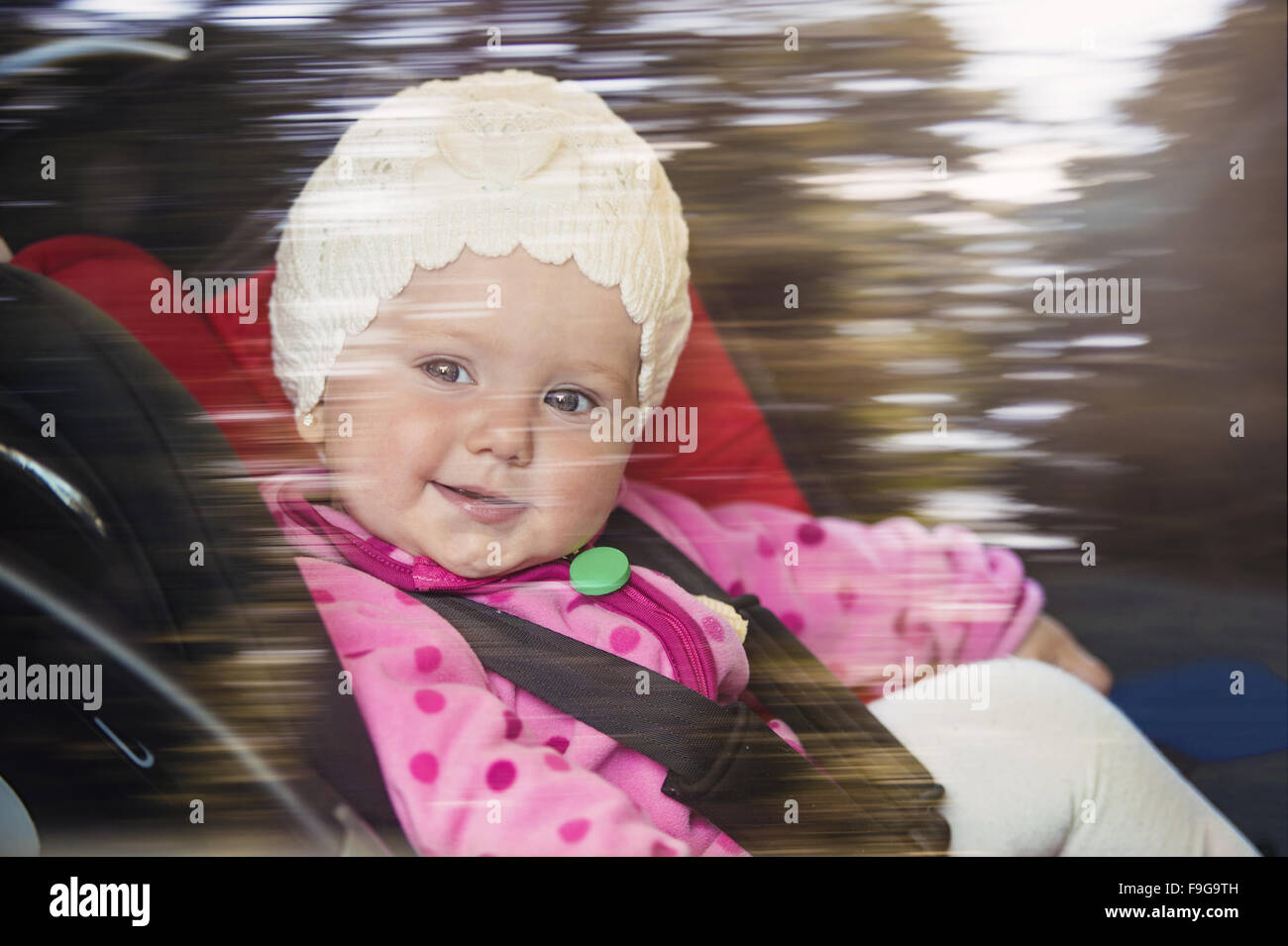 Little Baby girl in un auto in un seggiolino per bambini Foto Stock