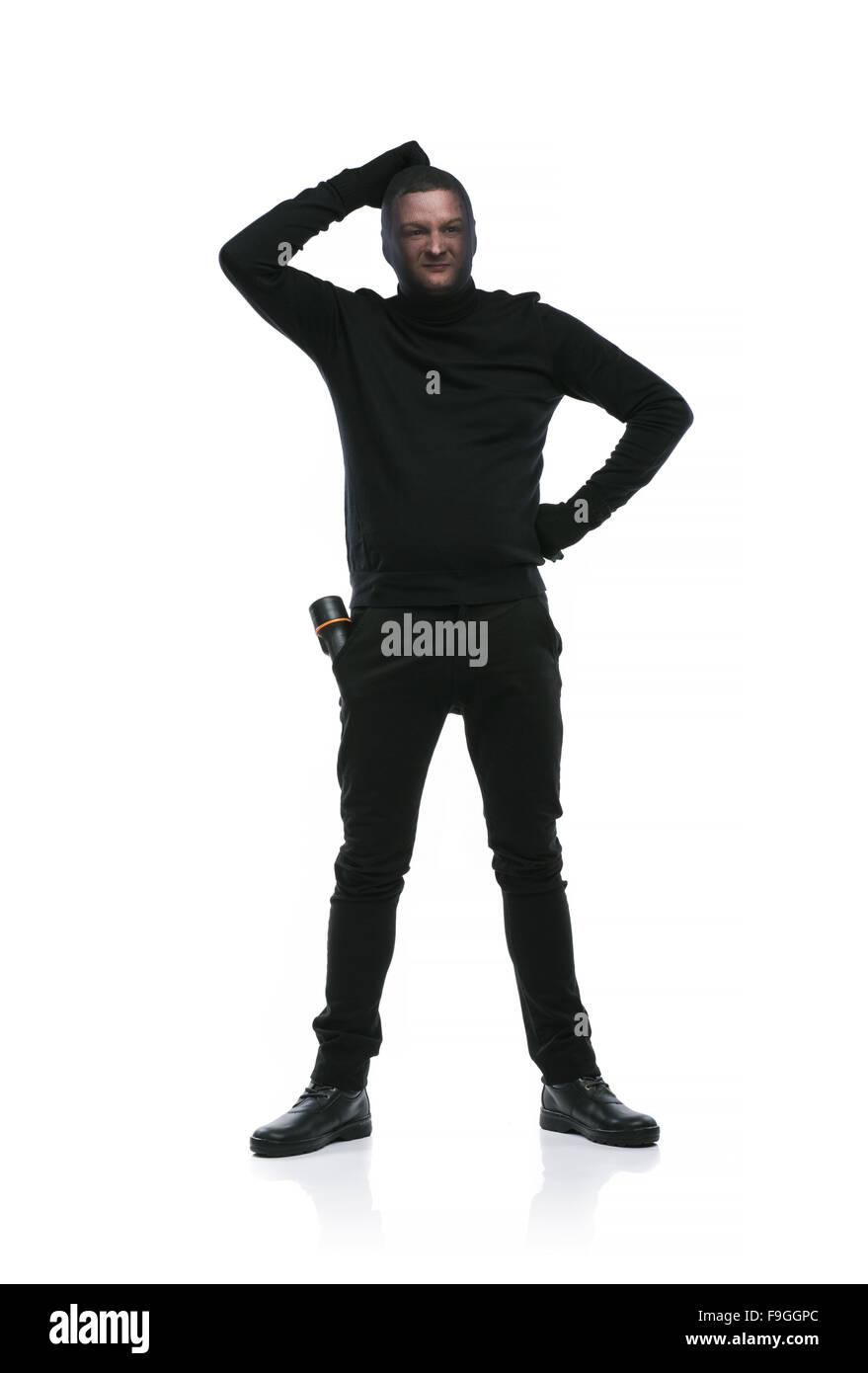 Ladro in azione con passamontagna sul suo volto, vestito di nero. Studio  shot su sfondo bianco Foto stock - Alamy