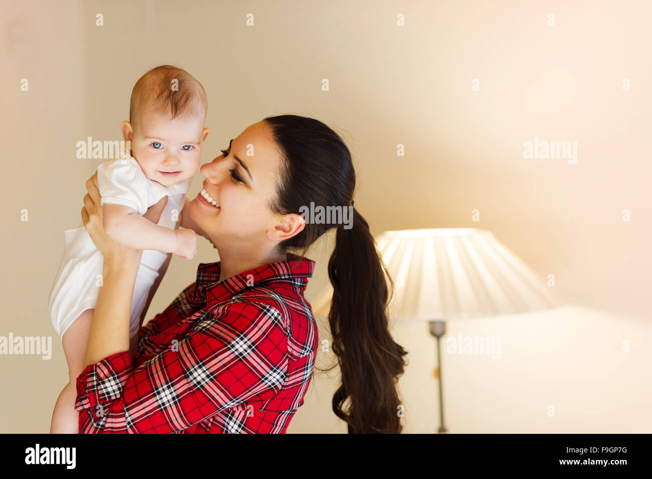 La madre che porta la sua piccola bambina tra le sue braccia. Foto Stock