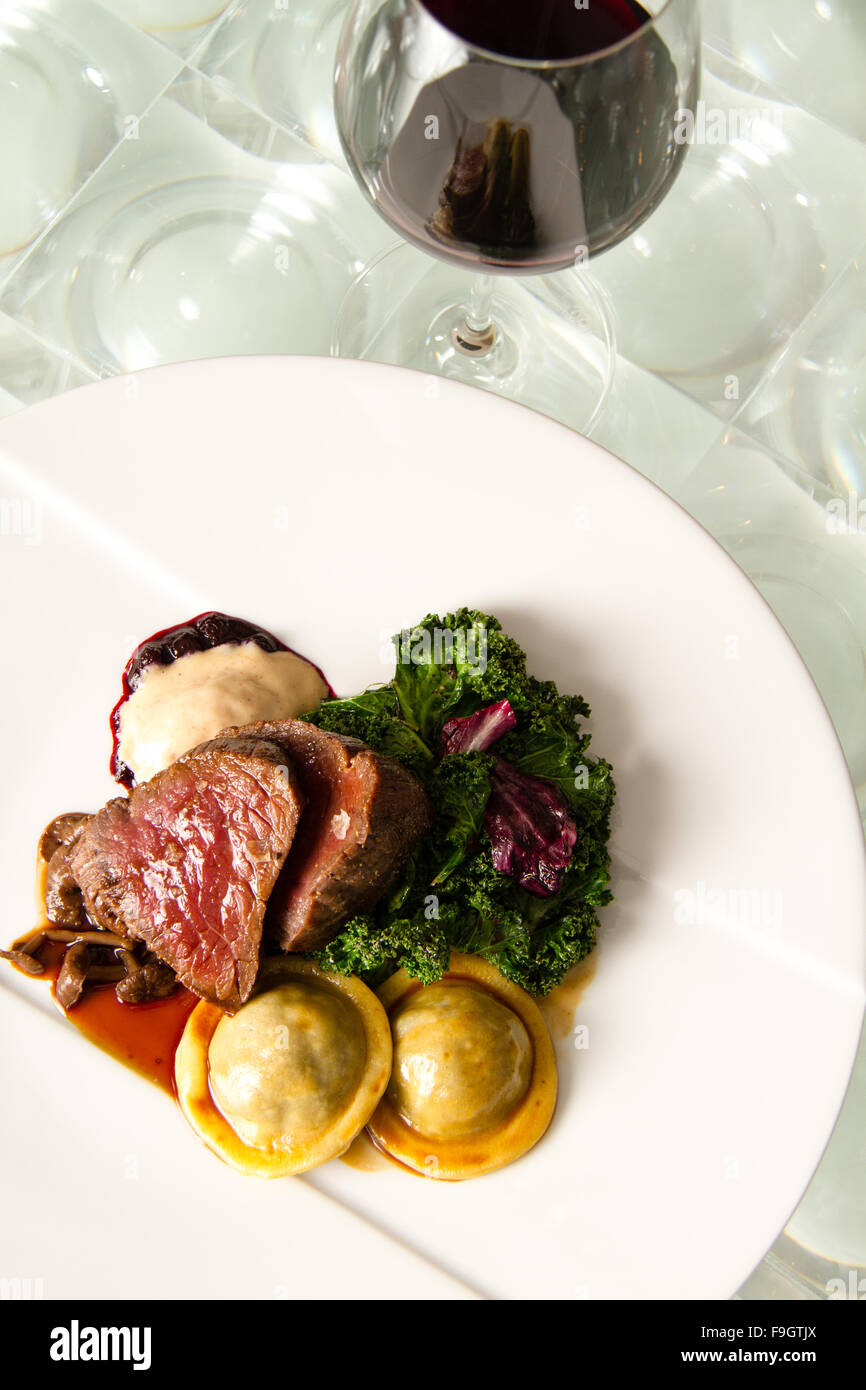 Lombo affumicato di elk con pan di zenzero ravioli, huckleberry composta, decapare i finferli e ghiacciate crema chanterelle Foto Stock