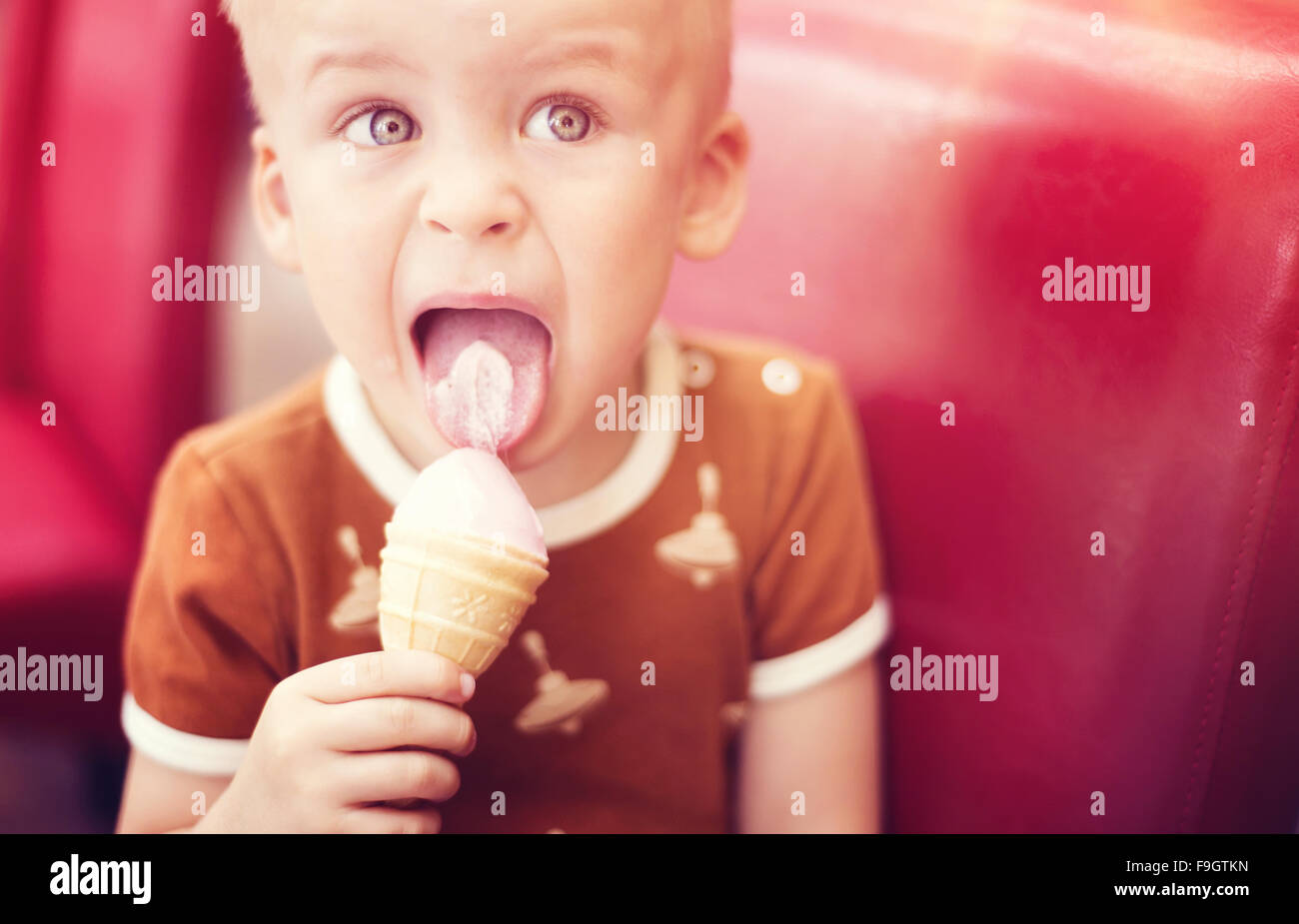 Little Boy godendo il gelato in cafe Foto Stock