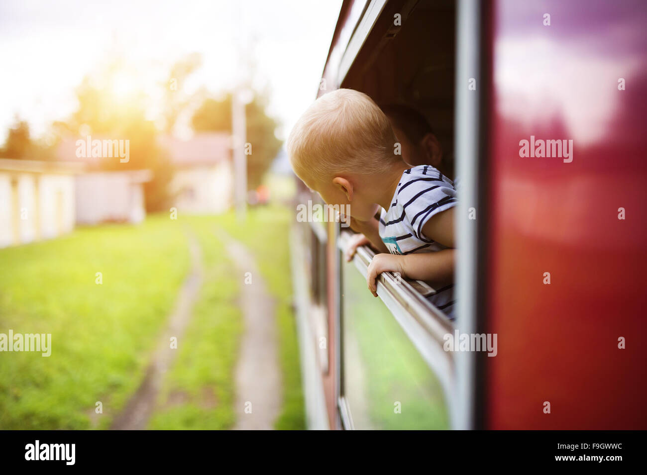 Little Boy viaggiando in treno guardando fuori dalla finestra. Foto Stock