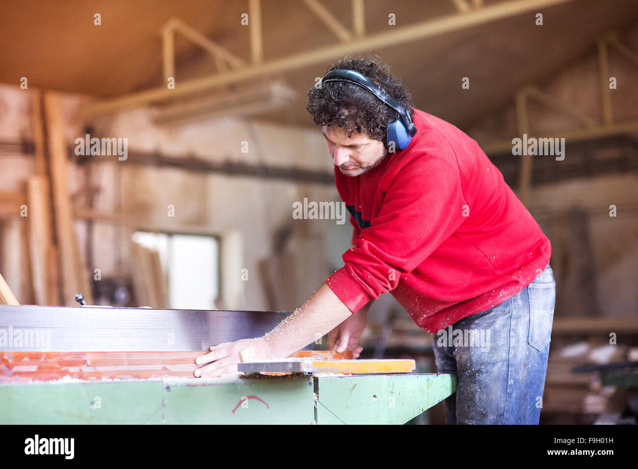 Carpenter lavora con legno elettrico ruspa nel suo laboratorio Foto Stock