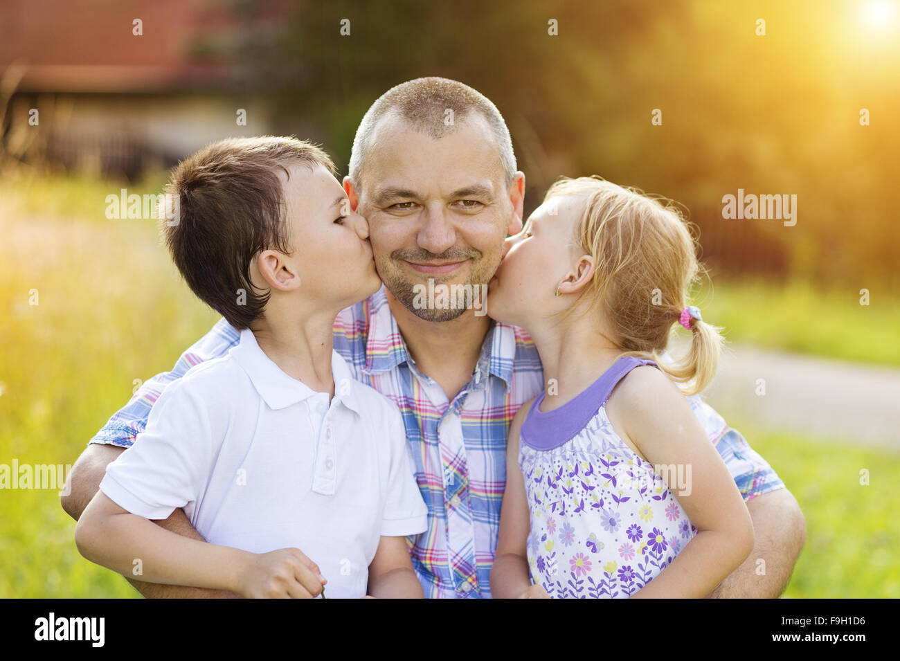 Padre con i suoi due bambini di trascorrere del tempo insieme al di fuori nel verde della natura. Foto Stock