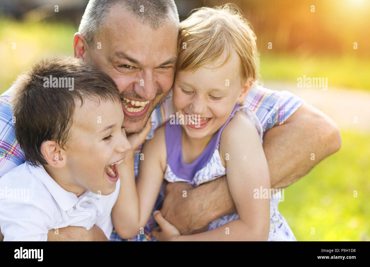 Padre con i suoi due bambini di trascorrere del tempo insieme al di fuori nel verde della natura. Foto Stock