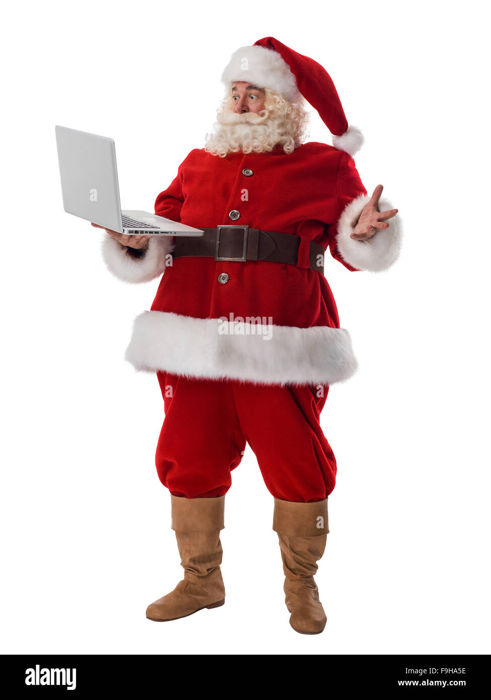 Santa Claus holding laptop a piena lunghezza verticale. Isolato su sfondo bianco Foto Stock