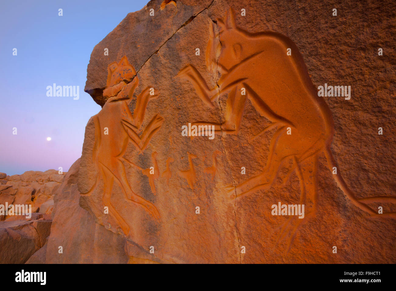 Arte rupestre al calare della luna a Wadi Methkandoush, Libia , deserto del Sahara , combattendo le figure fino a 10.000 anni, Fauna selvatica periodo così Foto Stock