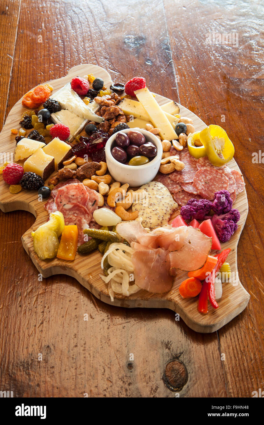 Il maiale a forma di scheda di salumi con formaggi, salumi, verdure sottaceto, marmellate, noci, frutta, olive e crostini, succulenti Cafe Foto Stock