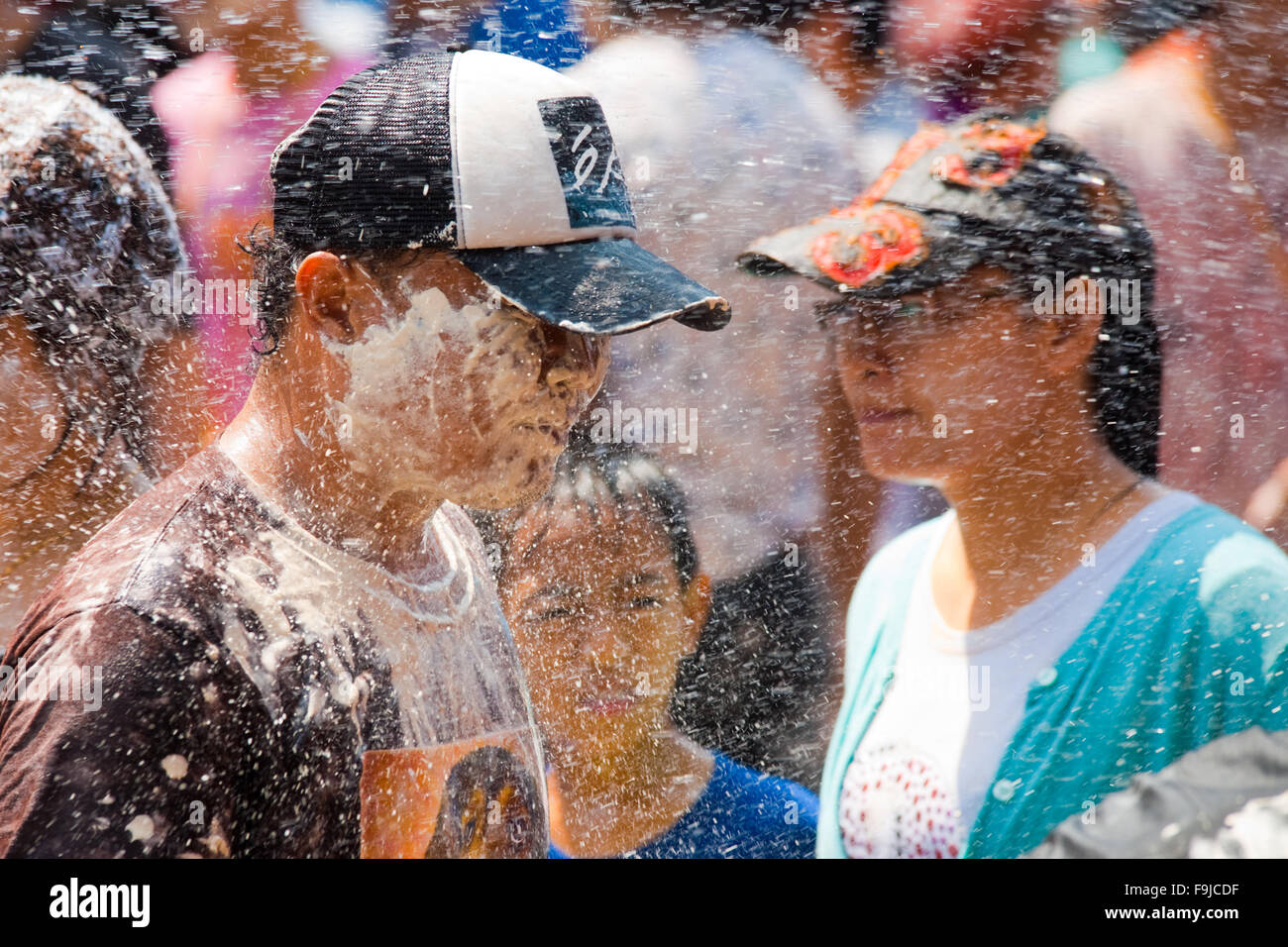 Reveler tailandese è irrorato da uno spruzzo di acqua e polvere bianca durante il Songkran, il tradizionale nuovo anno festival Foto Stock