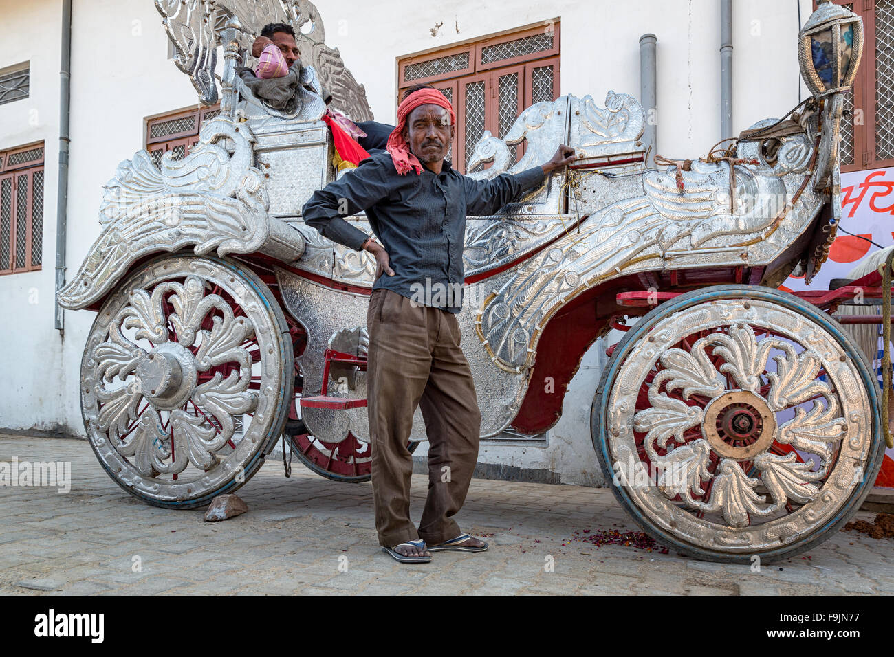 Due uomini con la loro carrozza d'argento decorata per matrimoni a Pushkar, Rajasthan, India Foto Stock