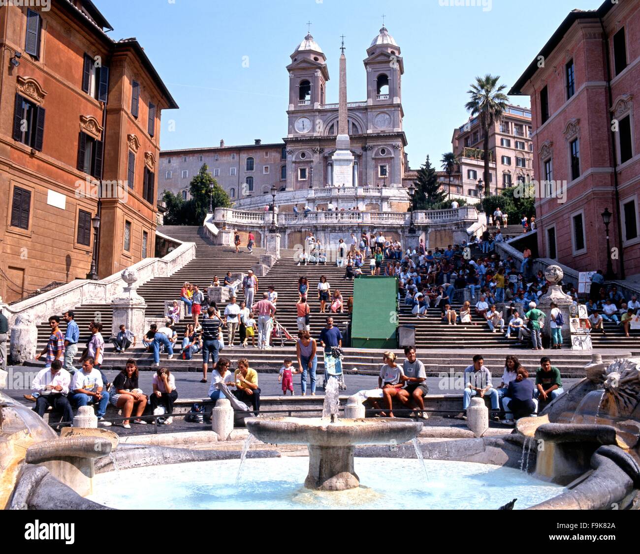 I turisti seduti sulla scalinata di Piazza di Spagna con una fontana in primo piano, Roma, Italia, Europa. Foto Stock
