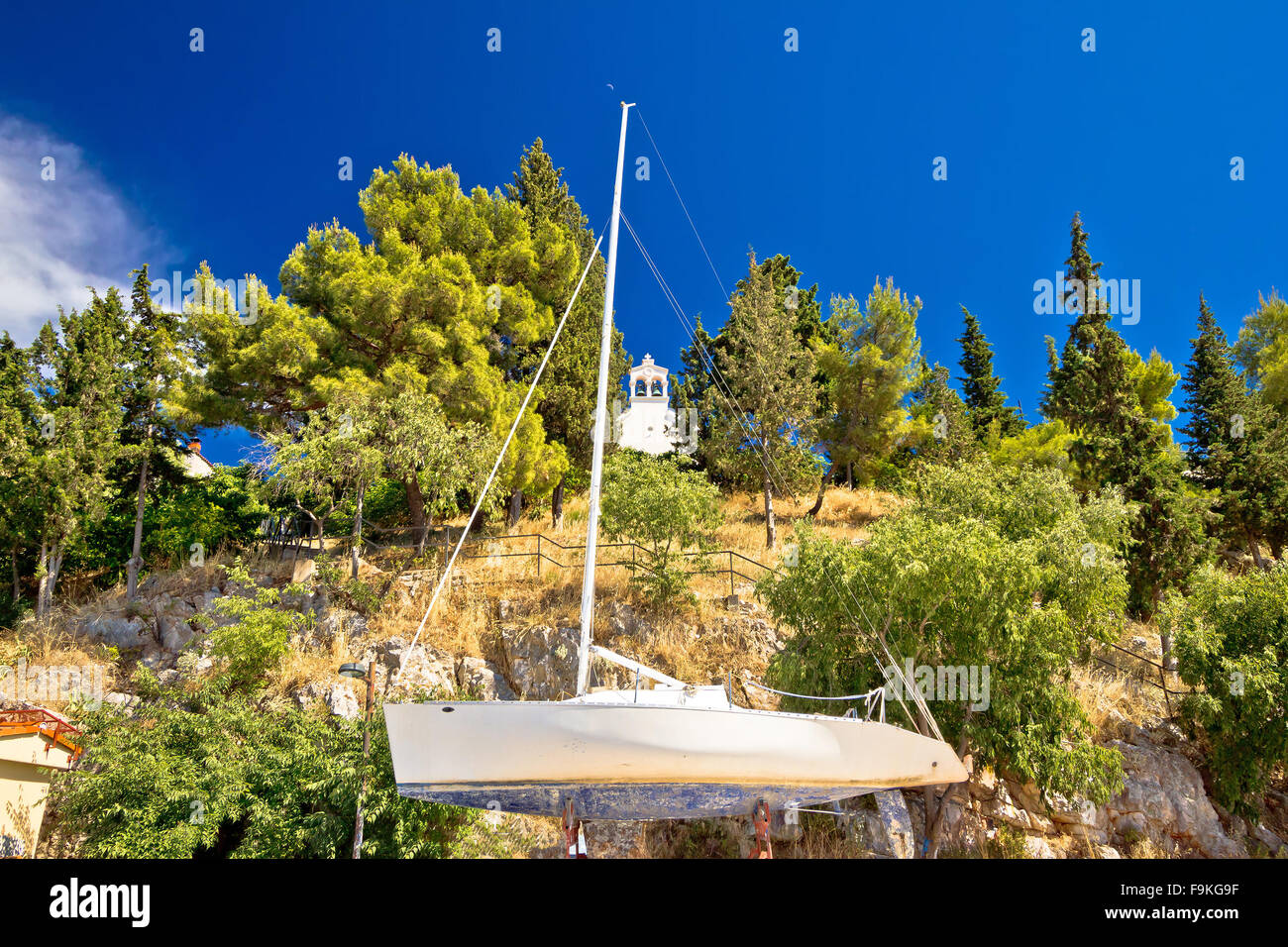 Barca a vela sul bacino di carenaggio e cappella di pietra di Sibenik, Croazia Foto Stock