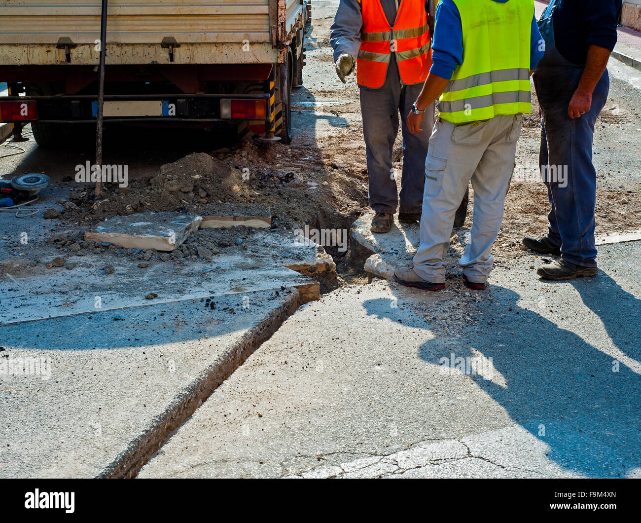 I lavoratori durante la costruzione della rete a banda larga con fibra di vetro in una strada di città Foto Stock