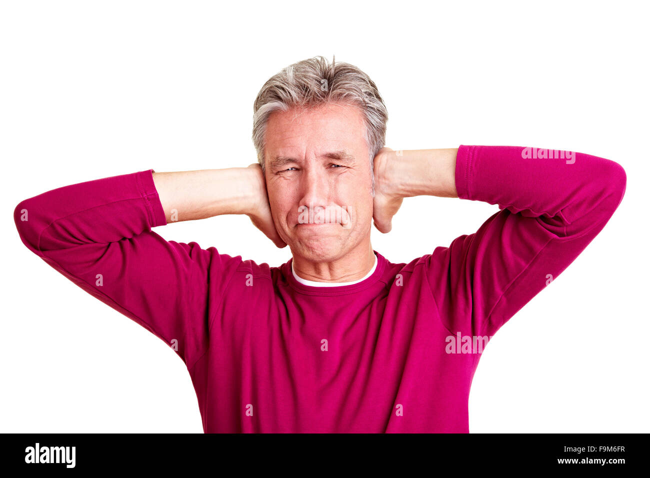 Frustrati senior uomo chiudendo il suo orecchio con le mani Foto Stock