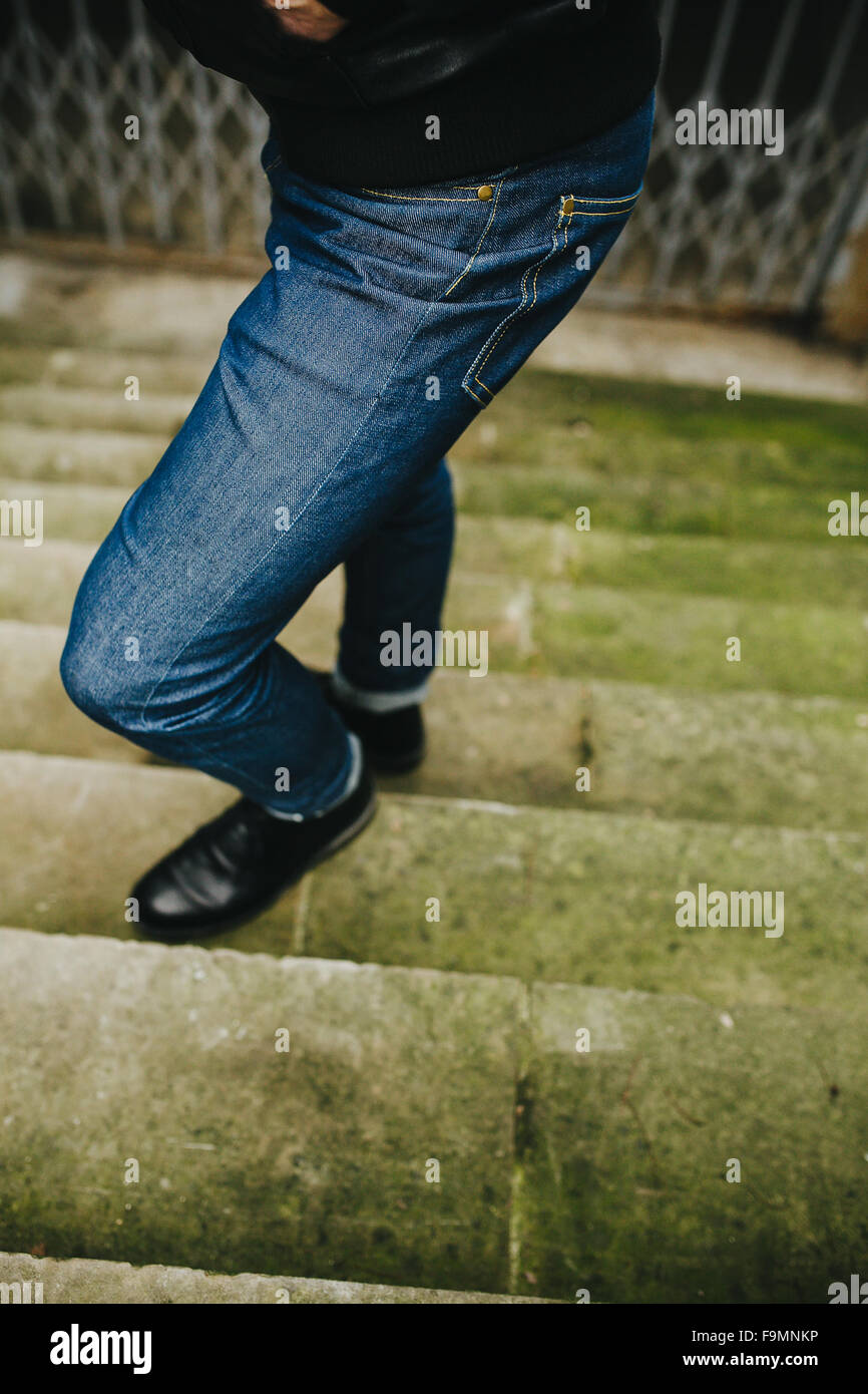 Fiducioso uomo in posa di cimosa jeans Foto Stock