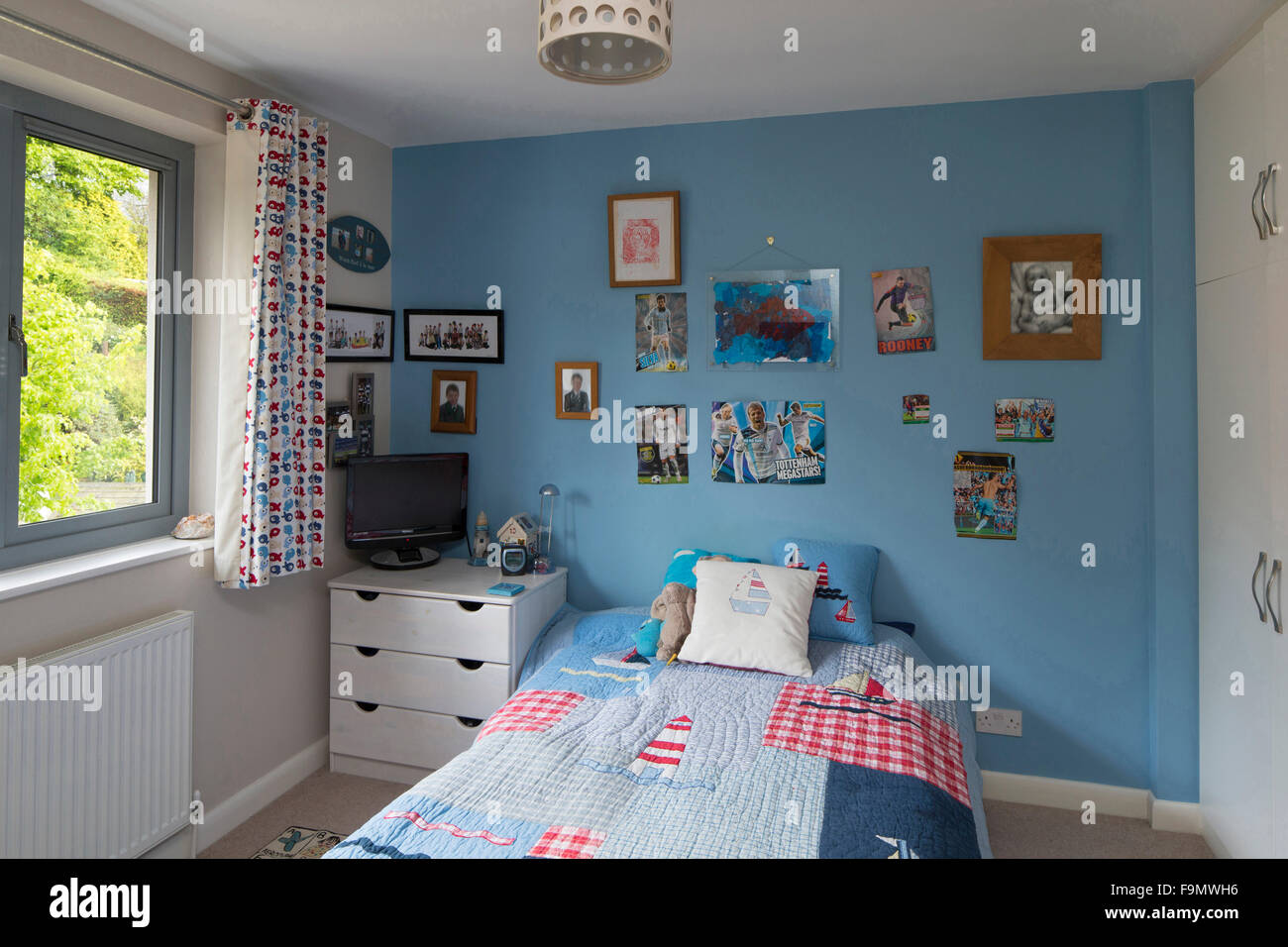 Un ragazzo in camera da letto in una moderna casa di famiglia. Foto Stock