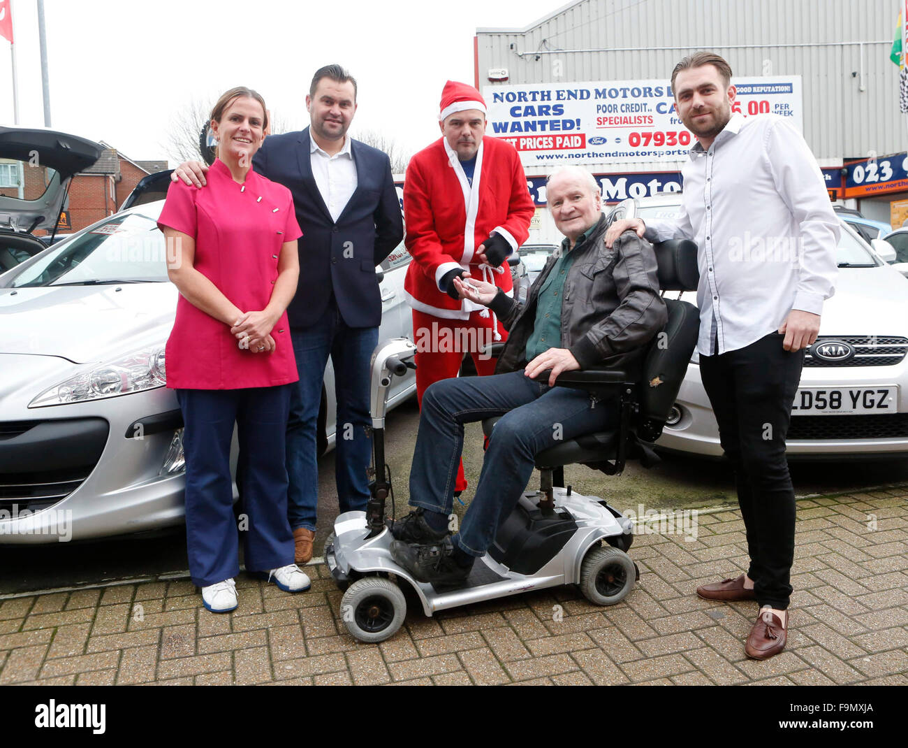 Northend, Portsmouth, Hampshire, giovedì 17 dicembre 115 foto di Debbie ampia personale al North End Motors proprietario Dan Oreilly Stephen Hobbs vestito come Santa Ron Mitchell (seduto) e Antony Spencer che aveva dato l'anno 68 ex Royal Navy Submariner Ron una sostituzione scooter dopo vili ladri hanno rubato la sua dalla sua porta la domenica mattina in Milton, Portsmouth, Hampshire . Credito: uknip/Alamy Live News Foto Stock