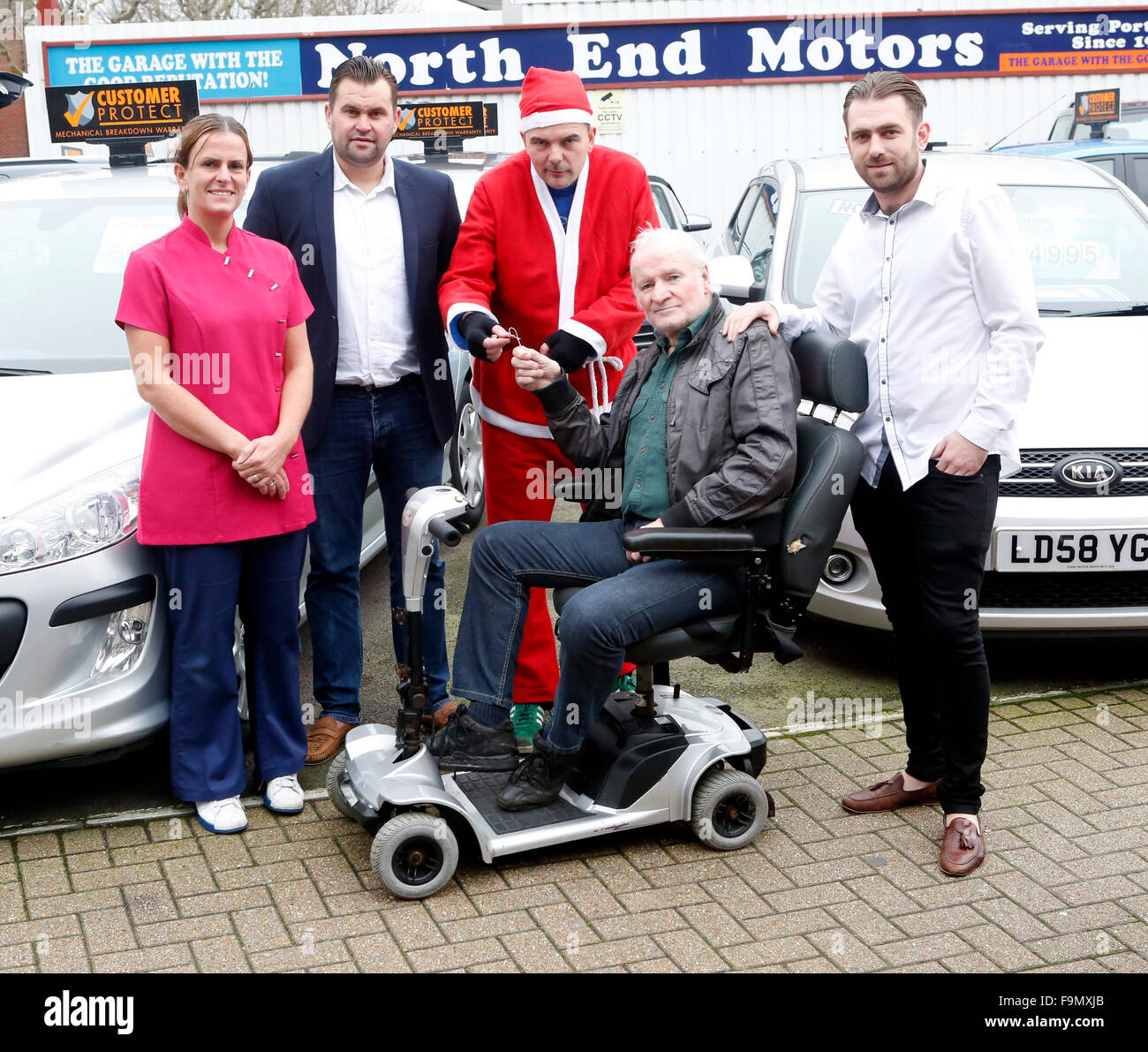 Northend, Portsmouth, Hampshire, giovedì 17 dicembre 115 foto di Debbie ampia personale al North End Motors proprietario Dan Oreilly Stephen Hobbs vestito come Santa Ron Mitchell (seduto) e Antony Spencer che aveva dato l'anno 68 ex Royal Navy Submariner Ron una sostituzione scooter dopo vili ladri hanno rubato la sua dalla sua porta la domenica mattina in Milton, Portsmouth, Hampshire . Credito: uknip/Alamy Live News Foto Stock