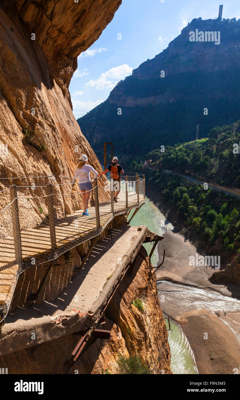 Walkers sul El Caminito del Rey passerella, immobilizzato per le ripide pareti di una stretta gola a El Chorro, Malaga, Andalusia, Spagna Foto Stock
