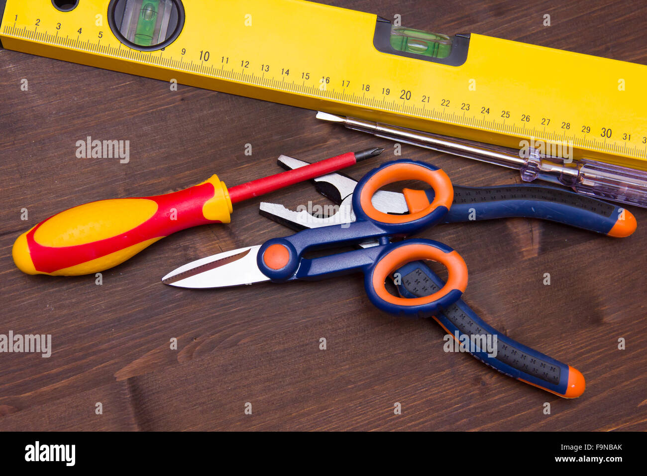 Strumenti di lavoro sparsi su un tavolo di legno Foto Stock