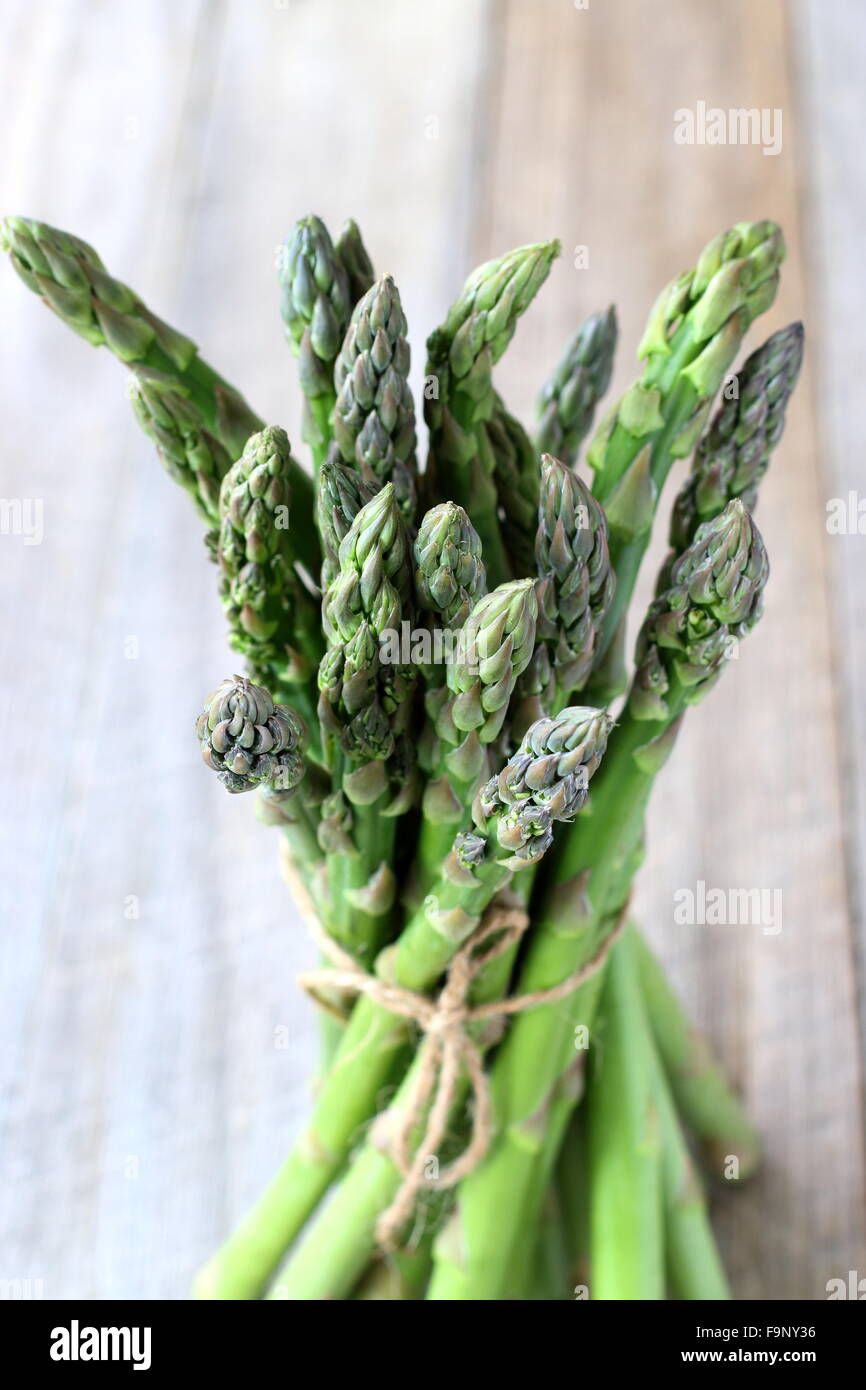 Close up di un mazzetto di asparagi su una tavola di legno Foto Stock